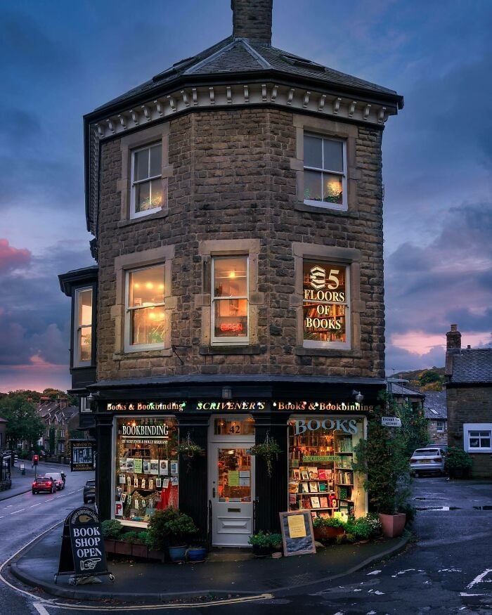 Livraria aconchegante e grandiosa com luzes quentes em um edifício histórico de pedra, exibindo um charme de biblioteca mágica.